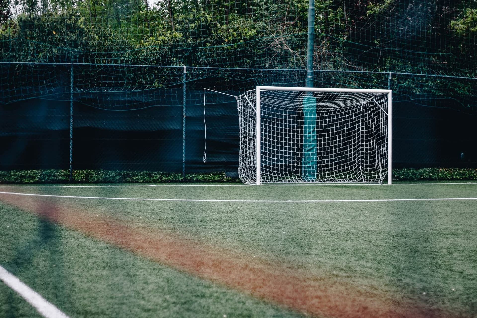 La porta del campo esterno in erba sintetica del Derbyteam, circondata dal verde